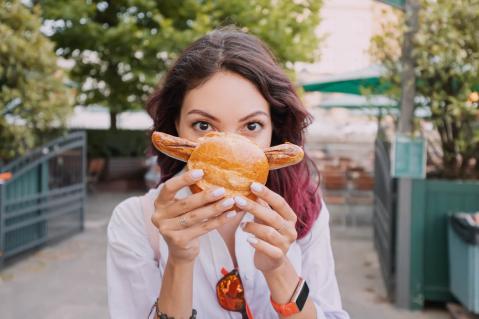 Junge Frau mit Bratwurst im Brötchen