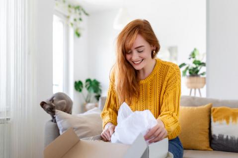 Junge Frau packt Paket aus