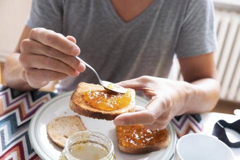 Mann isst Toast mit Marmelade