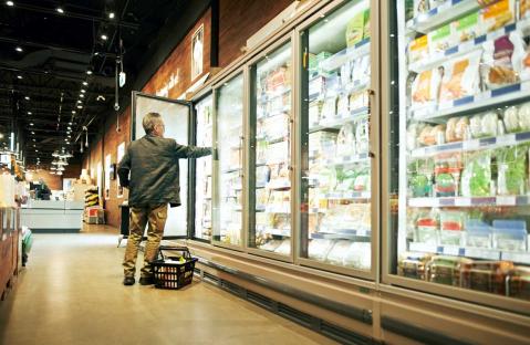 Mann kauft Fisch im Supermarkt