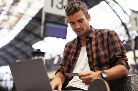 Mann mit Laptop und Kreditkarte