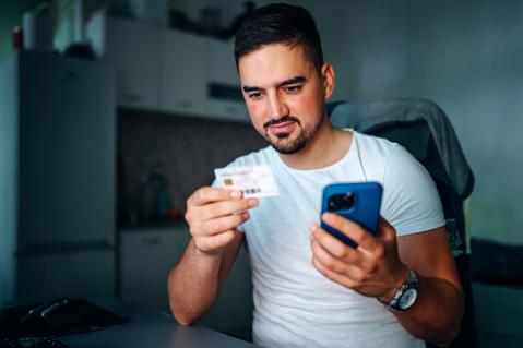 Mann mit Smartphone und Karte in der Hand