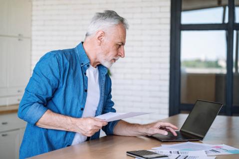 Mann schaut kritisch auf einen Laptop