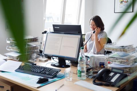 Mitarbeiterin der Verbraucherzentrale Hamburg vor Computer und am Telefon