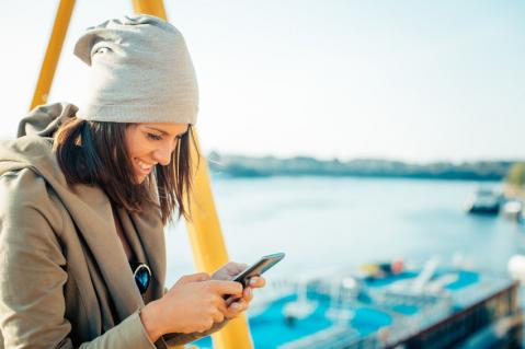 Junge Frau schaut auf ihr Smartphone