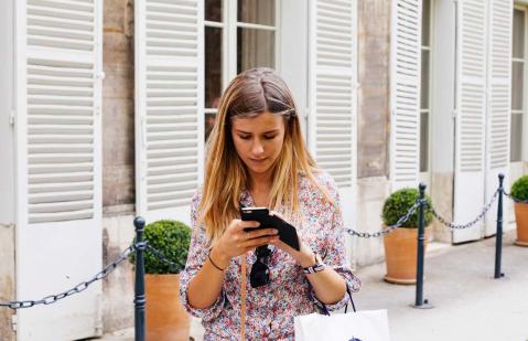 Junge Frau schaut auf ihr Smartphone