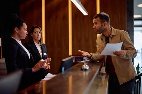 Unzufriedener Hotelgast an Rezeption