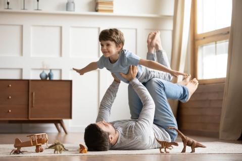 Vater spielt mit Sohn auf Fußboden