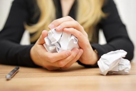 Nahaufnahme einer Frau, die zerknülltes Papier in der Hand hält